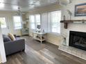 Cozy living room with wood floors, a fireplace, and lots of natural light at 1001 Palmetto Blvd, Edisto Island, SC 29438
