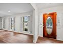 Inviting entryway showcasing hardwood floors, decorative front door with glass, and white plantation shutters at 1043 Dominion Dr, Hanahan, SC 29410