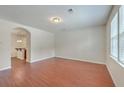 A bright living room with hardwood floors and neutral walls leading into the kitchen area at 1064 Lexi Ct, Ladson, SC 29456