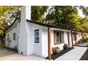 Angled exterior shot showcasing new white brick paint, a dark roof and updated wooden shutters at 1129 Dickson Ave, Hanahan, SC 29410