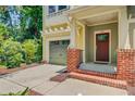 Close-up of the townhome featuring a garage, brick accents, and a welcoming front porch at 1184 Dingle Rd, Mount Pleasant, SC 29466