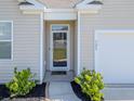 Close-up of the home's front door featuring glass, small garden area and well-manicured bushes at 123 Lagoona Dr, Summerville, SC 29483