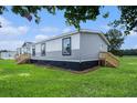 Manufactured home with a wood stair entrance and attractive gray and white siding at 1326 Givhans Rd, Ridgeville, SC 29472