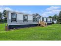 Classic manufactured home with a wood stair entrance and meticulous landscaping at 1326 Givhans Rd, Ridgeville, SC 29472