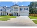 Charming two-story home with a welcoming front porch, attached garage and manicured lawn at 1888 Nola Run, Summerville, SC 29485