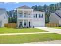 Charming two-story home with a welcoming front porch, attached garage and manicured lawn at 1888 Nola Run, Summerville, SC 29485