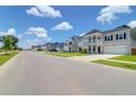 Street view showcasing the charming neighborhood with well-maintained homes and manicured lawns at 1888 Nola Run, Summerville, SC 29485