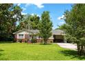 Lovely single-story home with a lush green lawn, mature trees, and an attached carport, offering comfort and convenience at 1900 Morgan Ave, North Charleston, SC 29406