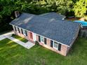 Brick home with a red front door, dark shutters, well-maintained lawn, and a pool in the backyard at 214 E Edgefield Dr, Summerville, SC 29483