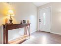 Inviting foyer with hardwood floors, a decorative table with a lamp, and a white front door at 214 E Edgefield Dr, Summerville, SC 29483