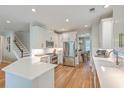 Modern kitchen featuring white cabinets, stainless steel appliances, quartz countertops, and hardwood flooring at 2150 Terrabrook Ln, Charleston, SC 29412