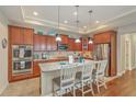 Stylish kitchen featuring stainless steel appliances, wooden cabinets, granite countertops, and an island with barstool seating at 269 Village Stone Cir, Summerville, SC 29483