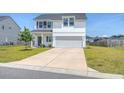 Charming two-story home with white siding, a well-manicured lawn, and a two car garage at 299 Lucca Dr, Summerville, SC 29486