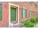 View of townhouse front entrance with brick facade, shutters, and green door at 302 Springview Ln # 7, Summerville, SC 29485