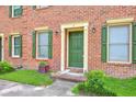 Close-up of brick townhouse featuring a green front door and decorative shutters at 302 Springview Ln # 7, Summerville, SC 29485