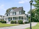 Beautiful blue two-story home with a spacious front porch and manicured lawn showcasing its curb appeal at 3513 Flowering Oak Way, Mount Pleasant, SC 29466
