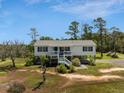 Charming raised beach house with white siding, blue shutters, and a welcoming front porch staircase at 3810 Marshfield Rd, Johns Island, SC 29455