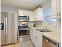 Modern kitchen with stainless steel appliances, white cabinetry, and a bright window at 415 Parkdale Dr # 6D, Charleston, SC 29414