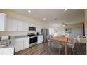 Bright kitchen featuring stainless appliances, granite counters, white cabinets, and an adjacent dining area at 5306 Bending Flats Way, Summerville, SC 29485