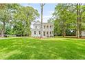 Charming two-story home featuring a welcoming front porch, surrounded by lush green grass and mature trees at 5710 Barbary Coast Rd, Hollywood, SC 29449
