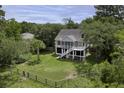 Beautiful raised home on a sprawling lot with a fenced yard and mature trees, offering privacy and space at 633 Stono Edge Dr, Charleston, SC 29412