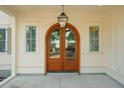 Close-up of an arched wood front door and sidelight windows at 743 Hills St, Mount Pleasant, SC 29464