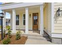 Inviting front porch with classic columns, wood door, and manicured landscaping at 791 Maynard Ln, Summerville, SC 29486