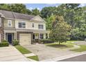 Inviting townhome showcasing a well-kept lawn, lush landscaping, and classic architectural details at 810 Bibury Ct, Charleston, SC 29414