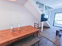 Dining area featuring a rustic wooden table, modern staircase, and a view of the outdoor area through sliding glass doors at 837 Club Cottage Rd, Edisto Island, SC 29438