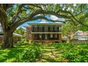 Expansive two-story home featuring a double balcony nestled beneath a majestic, mature tree canopy at 88 Smith St, Charleston, SC 29401