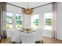 Bright breakfast nook with white chairs, round table, and stylish lighting fixture at 1027 Riverbed Retreat Ln, Summerville, SC 29483