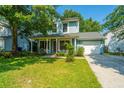 Charming two-story home with a welcoming front porch, attached garage, landscaped yard, and inviting curb appeal at 103 Toura Ln, Charleston, SC 29414