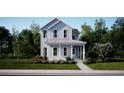 Inviting two-story home with a charming covered porch, set amidst lush greenery and mature trees at 114 Battle Boat Blvd, Summerville, SC 29485