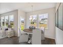 Cozy dining area with a round table, comfortable seating, and views of the backyard through large windows at 118 Orchard Blossom Ln, Summerville, SC 29485