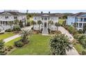 Elegant two-story home featuring a well-manicured lawn, mature palms, and a classic exterior at 1636 Rivertowne Country Club Dr, Mount Pleasant, SC 29466