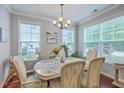 Bright dining area featuring a chandelier, windows, and hardwood flooring at 1666 Bridwell Ln, Mount Pleasant, SC 29466