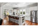 Bright, modern kitchen with a large island, stainless steel appliances, white cabinets and beautiful hardwood floors at 1878 Headquarters Plantation Dr, Johns Island, SC 29455