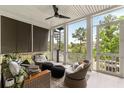 Relaxing screened porch with comfortable seating, a ceiling fan, spiral staircase, and serene outdoor views at 1878 Headquarters Plantation Dr, Johns Island, SC 29455