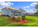 Large fenced backyard with a patio area, green grass and well-manicured garden beds with mulch at 202 Buttercup Ln, Summerville, SC 29486