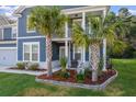 Inviting front yard featuring palm trees and well-maintained landscaping adds curb appeal to this beautiful home at 202 Buttercup Ln, Summerville, SC 29486