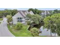 Charming townhome exterior featuring a private porch overlooking a serene pond at 202 Mariners Cay Dr, Folly Beach, SC 29439