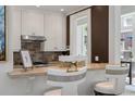 Kitchen pass-through featuring white cabinetry and a marble countertop with seating at 32 Prioleau St # J, Charleston, SC 29401