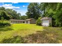 Large, green backyard featuring a detached garage and a separate storage shed for tools and equipment at 3347 Walter Drive, Johns Island, SC 29455