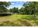 Expansive yard with a detached garage and a separate building surrounded by mature trees and a green lawn at 3347 Walter Drive, Johns Island, SC 29455