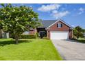 Well-maintained brick home with a two-car garage, lush lawn, and a tree-lined yard at 5008 Northfield Ct, Charleston, SC 29414