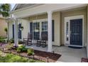 Inviting front porch features classic rocking chairs, plants, and a bright front door at 5011 W Liberty Meadows Dr, Summerville, SC 29485