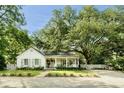 Inviting single-story home featuring a picturesque front yard, a cozy porch, and elegant white picket fence at 509 Klein St, Mount Pleasant, SC 29464