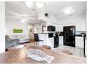 Bright kitchen with white cabinets, black appliances, and views of the dining and living areas at 700 Daniel Ellis Dr # 4107, Charleston, SC 29412