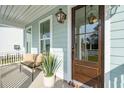 Inviting front porch with comfortable seating, decorative plants, and a stylish door with glass panels at 705 Maynard Ln, Summerville, SC 29486