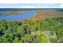 Beautiful aerial view of the home nestled among trees with a river view in the background at 7074 W Constellation Dr, North Charleston, SC 29418